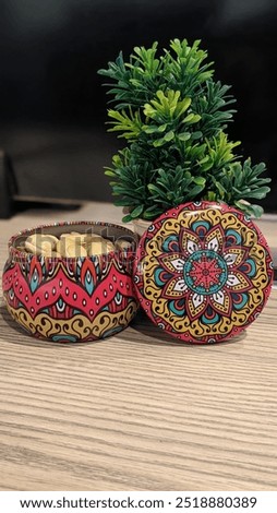 A colorful small pot adorned with traditional Pakistani truck art, featuring bold patterns and striking hues. An ideal piece to bring a vibrant touch of cultural heritage and artistry to any decor.