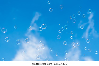 Colorful soap bubbles in the air on blue sky background. - Powered by Shutterstock