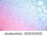 Colorful soap sud bubbles create an abstract pattern with purple and blue hues on a smooth surface.