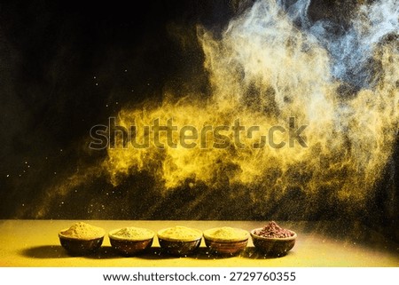 Colorful spice powder exploding over bowls with aroma