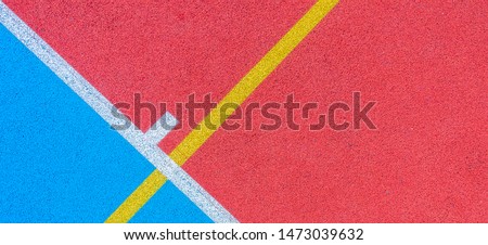 Colorful sports court background. Top view to red and blue field rubber ground with white and yellow lines outdoors