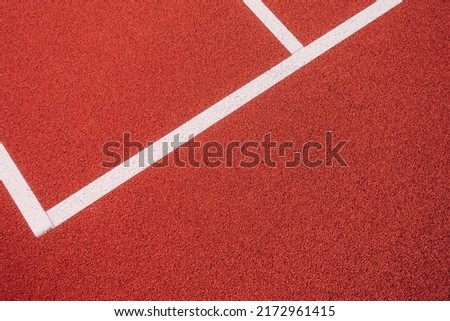 Colorful sports court background. Top view to red field rubber ground with white lines outdoors