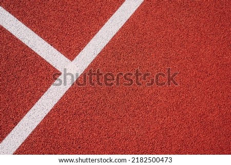 Colorful sports court background. Top view to red field rubber ground with white lines outdoors