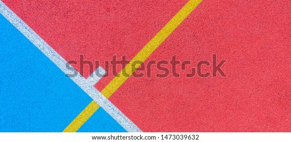 Colorful\
sports court background. Top view to red and blue field rubber\
ground with white and yellow lines\
outdoors