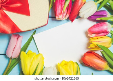 Colorful Spring Tulip Flowers With Decorative Giftbox And Blank Photo On Light Blue Wooden Background As Greeting Card. Mothersday Or Spring Concept.