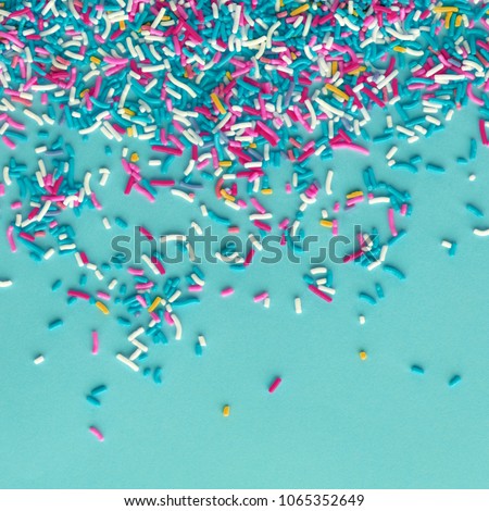 Colorful sprinkles on a blue background, top view with copy space