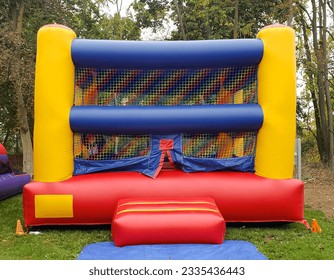 Colorful square children's bounce house with yellows, blues, and reds - Powered by Shutterstock