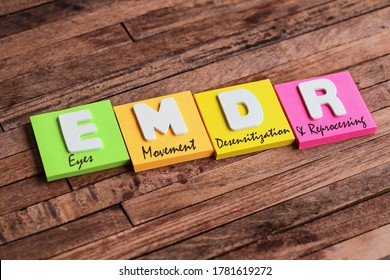 Colorful square papers with wooden white letters for the English acronym word, EMDR - Shutterstock ID 1781619272