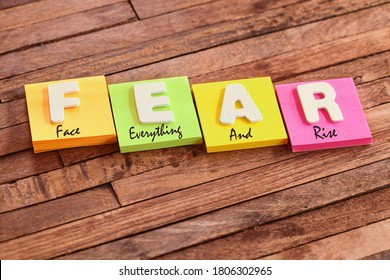 Colorful square papers with wooden white letters for the acronym word FEAR means Face Everything And Rise - Shutterstock ID 1806302965