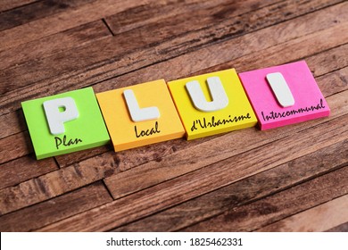 Colorful square papers with wooden white letters for the french acronym word PLUI means Intercommunal Local Urbanization Plan - Shutterstock ID 1825462331