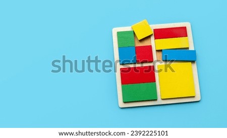 Colorful square and rectangular shape of puzzle isolated on blue background with copy space.