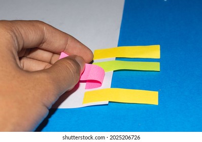 colorful sticky bookmarks pasted on white paper on blue background. education and business concept with copy space.