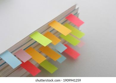 Colorful sticky notes sandwiched between books  - Shutterstock ID 1909941259