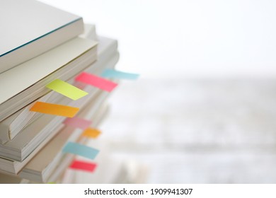 Colorful sticky notes sandwiched between books  - Shutterstock ID 1909941307