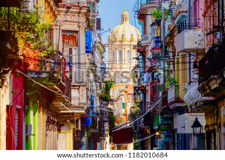 Colorful street in Old Havana with the Presidential Palace on the background