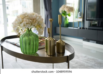 colorful and stylish living room with flower vase and gold trumpet on table.