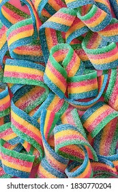 Colorful Sugar Candy Ribbon On A Pink Background Viewed From Above. Top View. Full Frame