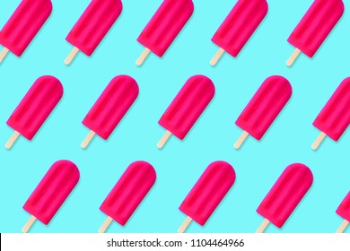 Colorful summer pattern. Bold pink popsicles on a pastel blue background. Top view.