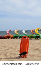 Colorful Summer Vacation At The Beach, Outdoor Playground For Kids With Recreation Nautic Equipment, Paddle Boat And Slide, In A Safe Enviroment With A Rescue Lifeguard On The Coast