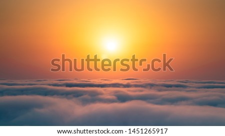 Similar – Image, Stock Photo The sun rises above the horizon, casting a warm glow over the misty mountains of Fuerteventura
