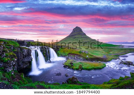 Colorful sunrise on Kirkjufellsfoss waterfall. Amazing morning scene near Kirkjufell volkano, Iceland, Europe.