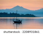 Colorful Sunrise Over Mt. Baker With a Sailboat in the Foreground. Beautiful calm morning in the San Juan Islands as the majestic Mt. Baker looms in the background.