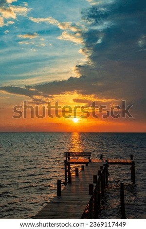 Colorful sunrise sky, clouds, Chesapeake Bay, and fishing pier 