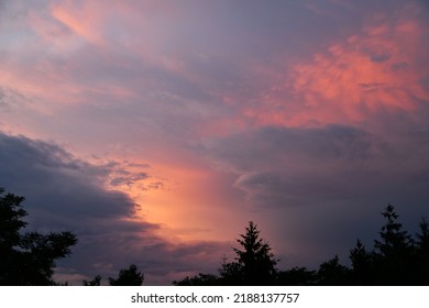 Colorful Sunset With Clouds And Treetops.