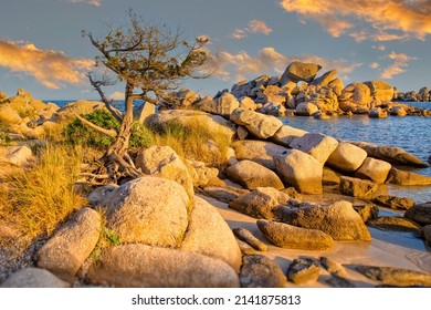 Colorful sunset over the rocks of Tamaricciu beach. View of the rocky coastline and the blue Mediterranean sea at the sunset, Tamaricciu beach, Corse du Sud, Corsica, France