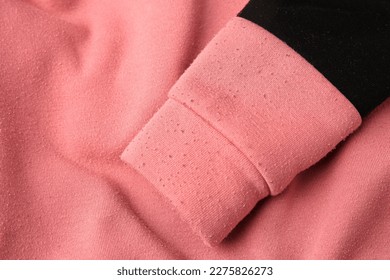 Colorful sweater with lint as background, top view. Before using of fabric shaver