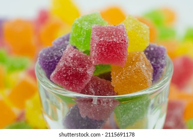 Colorful sweeties gummy candy. Cube candy in glass container. Cute background.