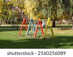 Colorful swingset in a sunny park on a clear autumn day