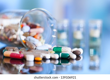 Colorful tablets with capsules and pills on blue background