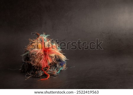 Colorful tangled threads on dark gray background