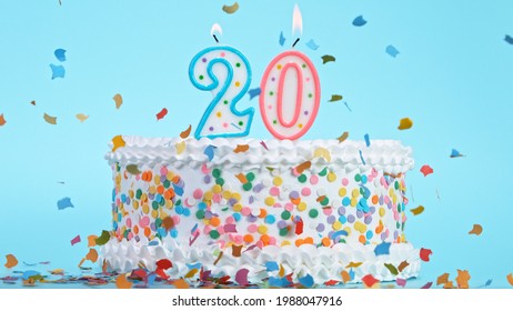 Colorful tasty birthday cake with candles shaped like the number 20. - Shutterstock ID 1988047916