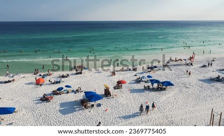 Colorful tents, beach lounge chairs, canopy and crowded of people swimming, relaxing, walking along white sandy shoreline with turquoise water, South Walton beach, Destin, Florida. Travel destination Stock photo © 