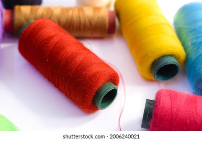 Colorful textile threads on a white background.