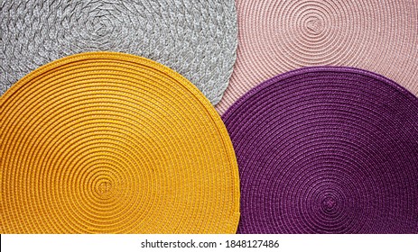 Colorful Texture Background. Four Round Table Mat Of Different Colors: Yellow, Purple, Gray And Pink.