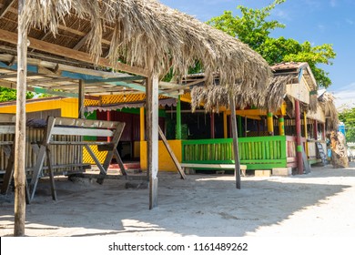 Colorful thatch roof board/wood and bamboo shops on sunny day along the Seven Mile Beach in Negril, Jamaica. Tropical summer vacation setting. No People.