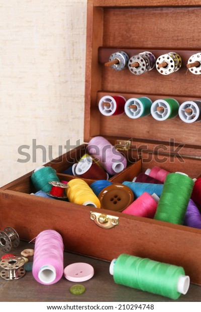 Colorful\
threads for needlework in wooden box close\
up