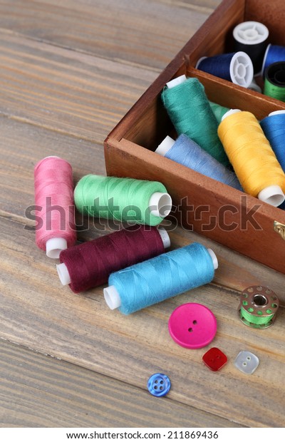 Colorful\
threads for needlework in wooden box close\
up