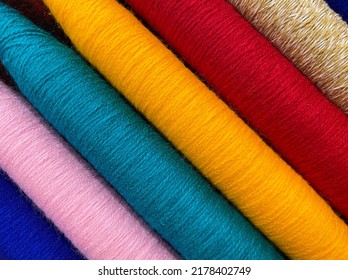 Colorful threads. Yarn. Bobbins with yarn. Fabric. Sewing threads. Skein of thread. Texture of colorful thread in spoolls.