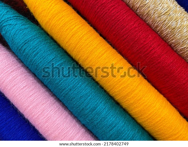 Colorful\
threads. Yarn. Bobbins with yarn. Fabric. Sewing threads. Skein of\
thread. Texture of colorful thread in\
spoolls.