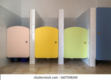 Colorful Toilet Doors In Elementary School Bathroom Interior.