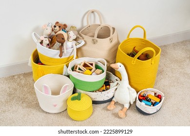Colorful Toy Storage Baskets in the children's room. Cloth stylish Baskets different sizes with toys and rag dolls. Organizing and Storage Ideas in nursery.  House cleaning.