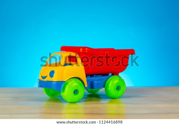 Colorful toy truck\
isolated on blue\
background
