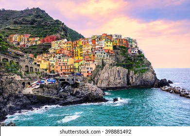 Colorful traditional houses on a rock over Mediterranean sea on dramatic sunset, Manarola, Cinque Terre, Italy