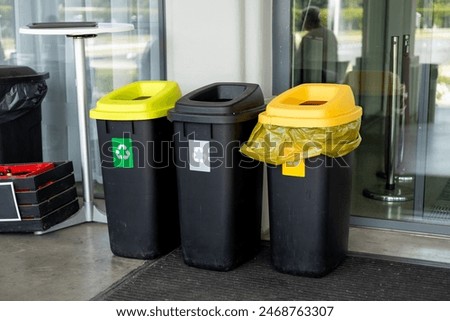 Colorful trash cans for sorting garbage. For plastic, glass, paper and others waste. Waste containers for garbage segregation in Poland, standing next to a wall