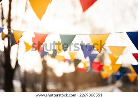 Colorful triangular flags against sunset sky.