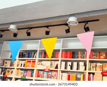 Colorful triangular flags hanging inside bookstore. Festive decoration, celebration and creative cultural space design.